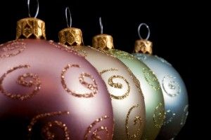 Receding diagonal row of decorative Christmas baubles with selective focus to the second ball on a dark background